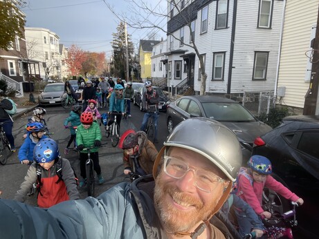 Smiling white guy me taking a selfie with a bunch of kids on bikes behind me